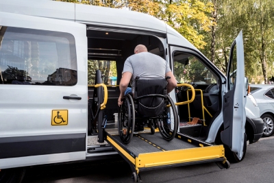 Personne à mobilité réduite qui monte dans une camionnette spécialisée